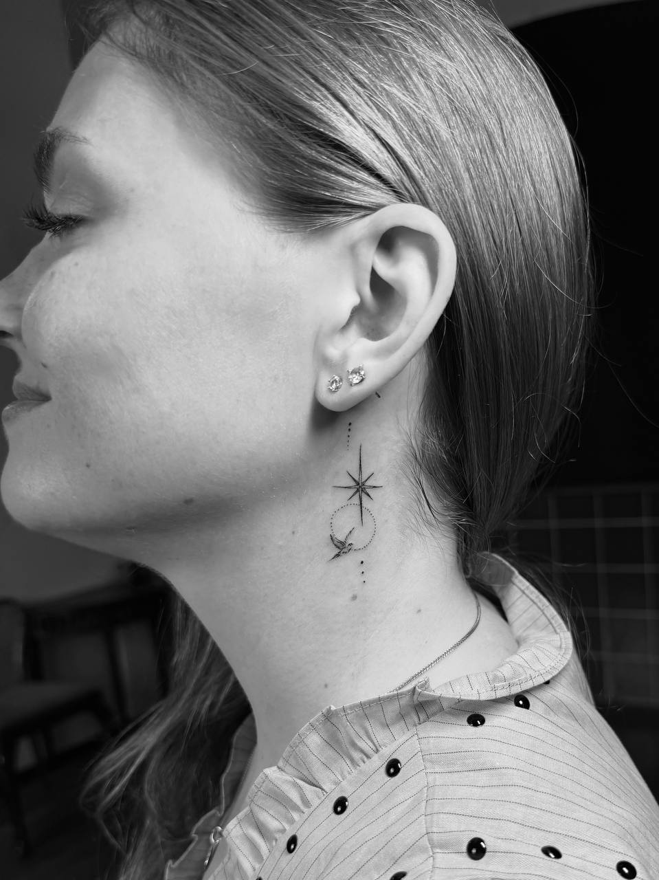 Fine line star tattoo behind the ear, done at STIN Tattoo Studio Prague